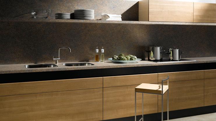 Küchenzeile aus Massivholz mit schwarzer Arbeitsplatte, Spülbecken und Wandregal